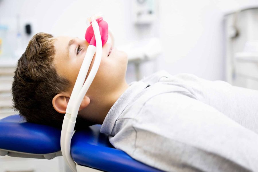 Junger Patient mit Lachgas-Nasenmaske auf dem Behandlungsstuhl